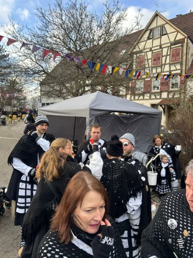 Menschen in Kostümen feiern eine Veranstaltung mit buntem Dekor und Festatmosphäre.