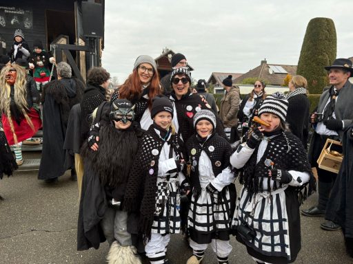 Gruppe in Kostümen mit Gesichtsbemalung, beim Festumzug im Freien.