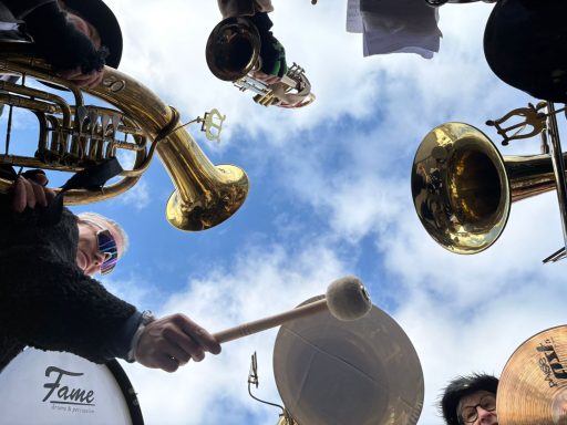 Blick auf Musiker mit verschiedenen Instrumenten vor blauem Himmel.