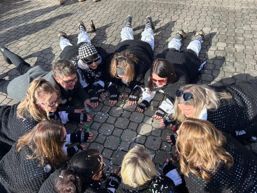 Gruppierung von Personen, die auf dem Boden liegen und Smartphones zur Aufnahme von Fotos verwenden.