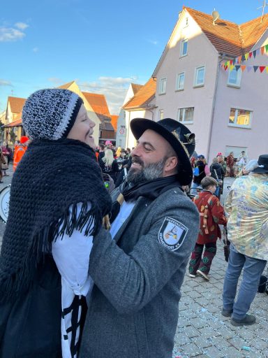 Ein Mann und eine Frau tanzen fröhlich auf einer Feier im Freien.